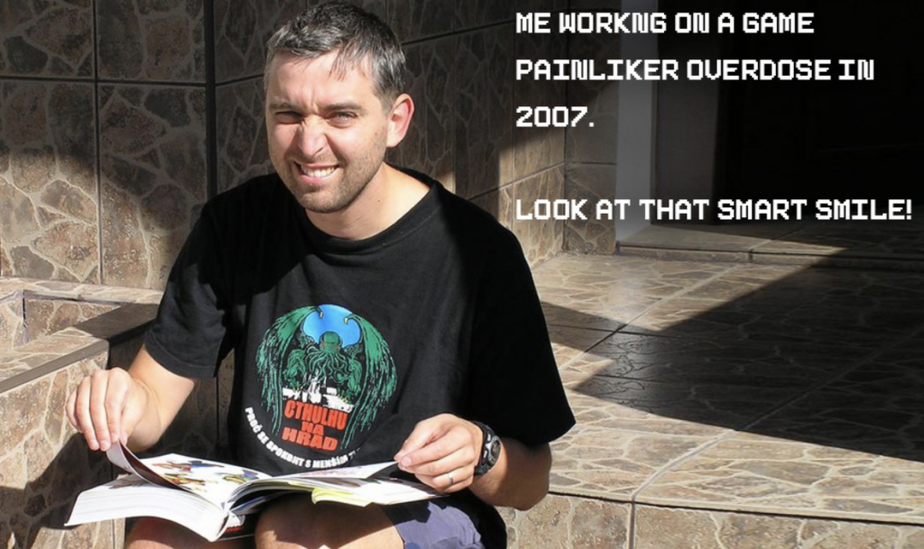 A man sitting down looking at a comic book smiling